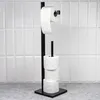 A black toilet paper stand with four rolls of toilet paper, set against a white tiled wall. Voir les images du produit