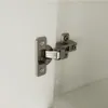 Close-up of a cabinet hinge on a white surface. Náhled obrázku produktu