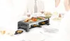 A group of people are gathered around a table, enjoying a meal with a raclette grill. Produktbild-Vorschau