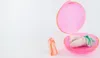 A pink case with earplugs inside and one earplug outside the case, on a white background. Produktbild-Vorschau