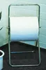 A roll of white paper on a metal stand in a room with a brick wall. Produktbild-Vorschau