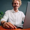 A man is inserting a USB drive into a laptop. Náhľad obrázku produktu