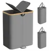 A laundry basket with two compartments and a lid, shown from the front. Two smaller, collapsed versions of the basket are shown to the right. Produktbild-Vorschau