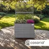 A grey rattan planter with a trellis, filled with pink and white flowers, sits on a stone patio in a garden. Anteprima dell’immagine prodotto