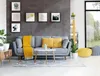A living room scene with a gray sofa, yellow throw pillows and blanket, and a coffee table. Náhled obrázku produktu