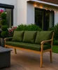 A wooden sofa with green cushions sits on a wooden deck, with a house and garden in the background. Náhľad obrázku produktu