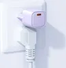 A purple USB-C charger plugged into a white wall socket, with a white power cord plugged into the socket below it. Anteprima dell’immagine prodotto