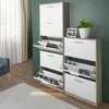 Two white and wood shoe cabinets are shown in a room with a green wall and a wooden floor. Produktbild-Vorschau