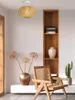 A living room scene with a woven pendant light, a wooden chair, dried flowers in a vase, and a bookshelf. Podgląd zdjęcia produktu
