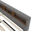 A close-up view of a gray upholstered headboard with built-in wooden shelves and a wooden slat bed frame. Produktbild-Vorschau
