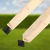 Two wooden beams are attached to black metal post anchors, set against a blurred background of green grass and a blue sky. Podgląd zdjęcia produktu