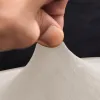 A hand is pinching a piece of beige fabric. Anteprima dell’immagine prodotto