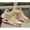 A person is holding a pair of beige safety shoes. Produktbild-Vorschau