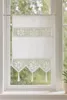 A white lace curtain hanging on a window. Produktbild-Vorschau
