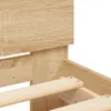 A close-up view of the corner of a wooden bed frame, showing the slatted base and the headboard. Produktbild-Vorschau