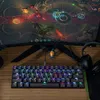 A gaming setup with a keyboard, monitor displaying a game, and headphones. Podgląd zdjęcia produktu