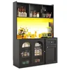 A black kitchen hutch with glass doors and a drawer, featuring various kitchen items and decorative elements, illuminated by a yellow LED light. Produktbild-Vorschau