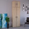 A tall, two-section cabinet with doors, placed against a wall with framed pictures and a painting nearby. Náhľad obrázku produktu