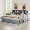 A gray daybed with a bookshelf headboard and two drawers is shown in a bedroom setting. Náhled obrázku produktu