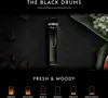 A perfume sample bottle is displayed on a dark, textured surface, surrounded by natural elements like bark and flowers, with descriptive text and visual indicators of scent profiles. Produktbild-Vorschau