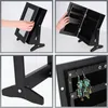 Collage of four images showing a black jewelry box with a mirror and storage compartments, including close-ups of its stand and interior. Produktbild-Vorschau