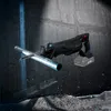 A black reciprocating saw is shown in action, cutting through a metal pipe, with debris flying around. Produktbild-Vorschau