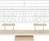 A white metal bunk bed frame with attached wooden shelves and desk surfaces, shown from a low angle against a white background. Produktbild-Vorschau