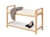 A wooden bench with two shelves, a cushion on the top shelf, and a blanket draped over it. A pair of black shoes is on the bottom shelf. Náhled obrázku produktu