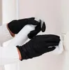 Hands wearing black gloves cleaning a light switch with a spray bottle and cloth. Produktbild-Vorschau