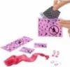 A person's hands are shown opening a pink package with question marks and a prohibition symbol on it. Several other pink items with question marks and a red ribbon are laid out on a white surface. Anteprima dell’immagine prodotto
