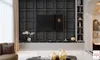A modern living room with a TV mounted on a textured black wall, a sleek entertainment unit, and decorative items. Náhled obrázku produktu