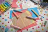 A collection of art supplies and children's toys scattered on a polka-dotted tablecloth. Voir les images du produit