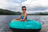 A woman is sitting in an inflatable ring on a lake. Anteprima dell’immagine prodotto