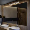 A modern bathroom with a large mirror reflecting a shower and vanity area. Produktbild-Vorschau