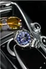 A watch and sunglasses are placed on the center console of a car. Produktbild-Vorschau