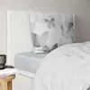 A close-up view of a bed with a white headboard, a light blue fitted sheet, a white duvet, and a pillow with a gray butterfly pattern. Produktbild-Vorschau