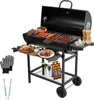 A black charcoal grill with food on it, accessories, and drinks. Produktbild-Vorschau