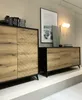 Two modern wooden sideboards with black legs and frames are displayed on a white platform against a light gray wall. Produktbild-Vorschau