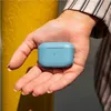 A person's hand holding a blue earbud case next to a yellow pole. Anteprima dell’immagine prodotto