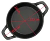 A top-down view of a black cast iron serving pan with red measurement lines and text indicating dimensions. Voir les images du produit