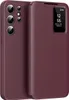 A burgundy leather flip case for a Samsung Galaxy S22 Ultra phone is shown with the flip cover partially open, revealing the phone's camera array and a small display window on the cover showing the time and date. Náhled obrázku produktu