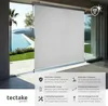 A white roller blind is shown partially covering a large glass sliding door, with a view of a swimming pool and landscape beyond. The bottom of the image contains marketing text and icons describing the product's features. Náhled obrázku produktu