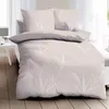 A neatly made bed with beige bedding featuring a white leaf pattern, set against a bright window. Produktbild-Vorschau