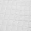 A close-up, overhead view of a white quilted mattress topper. Produktbild-Vorschau
