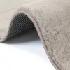 A close-up view of a beige rug, showing its texture and underside. Produktbild-Vorschau