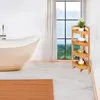 A bathroom scene with a bathtub, a corner shelf unit, and a window with a view. Podgląd zdjęcia produktu