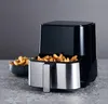 A black and silver air fryer filled with french fries, placed on a gray countertop. Produktbild-Vorschau