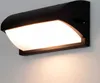 A black LED outdoor wall light mounted on a white wall. Náhľad obrázku produktu