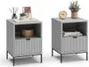 Two identical gray nightstands are displayed side-by-side against a white background. Each nightstand has an open shelf above a fluted drawer and is supported by thin black legs. Decorative items like books, a plant, a clock, and a vase with reeds are plac Voir les images du produit