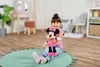 A young girl is sitting on a round rug, holding a Minnie Mouse plush toy. Produktbild-Vorschau